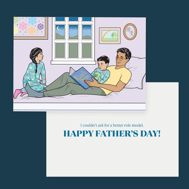 father reading a book to two children on a couch