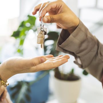 real estate agent giving house key to woman