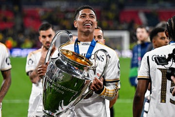 real madrid footballer jude bellingham smiles with joy as he holds the champions league trophy