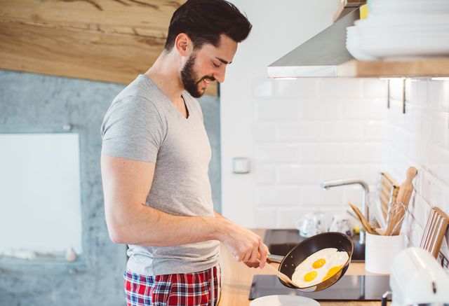 hombre haciendo huevos fritos