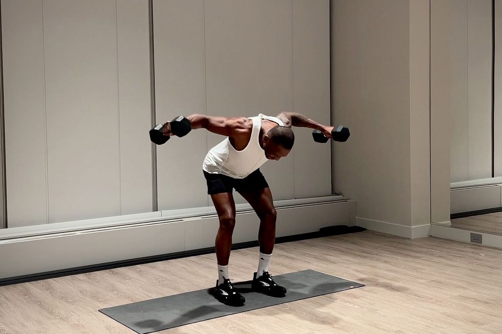 shoulder and arm workout, yusuf jeffers practicing rear delt fly exercise