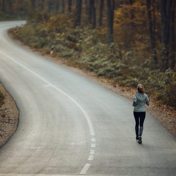 Rear view of a female athlete jogging on the road in nature. rear view of a female athlete jogging on the road in nature