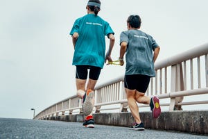 rear view of a visually impaired female triathlete running together with her guide