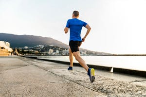 rear view of athlete jogging in city