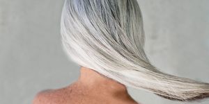 Rear view of bare shouldered mature woman with long grey hair