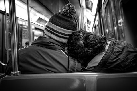 rear view of couple traveling on subway train