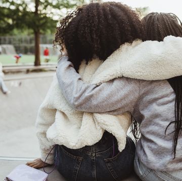 rear view of female friends with arms around at skateboard park
