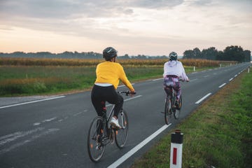 rear view of friends riding bicycles on road