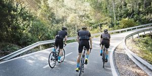 rear view of male friends cycling on road