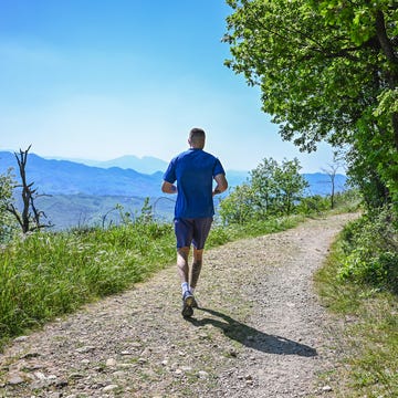 Rear view of man running in hills. rear view of man running in hills