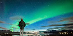 Rear View Of Man Standing By Sea Against Aurora Borealis