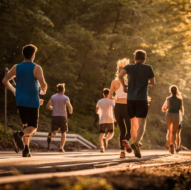 rear view of runners during a marathon race at sunset.
