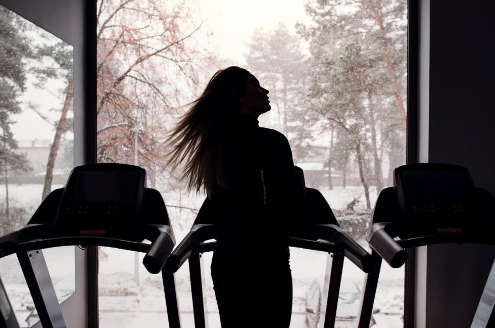 Rear View Of Silhouette Of Young Girl Or Woman Doing Cardio Workout In A Gym