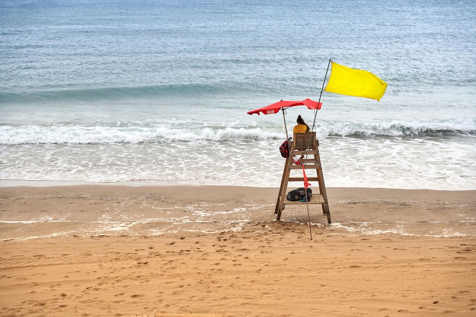 rear view of unrecognizable woman working as life guard at costline of a beach