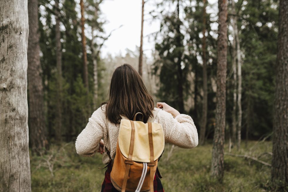 rear view of woman exploring in forest during vacation