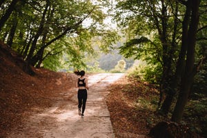 Rear view of woman jogging at park on sunny day