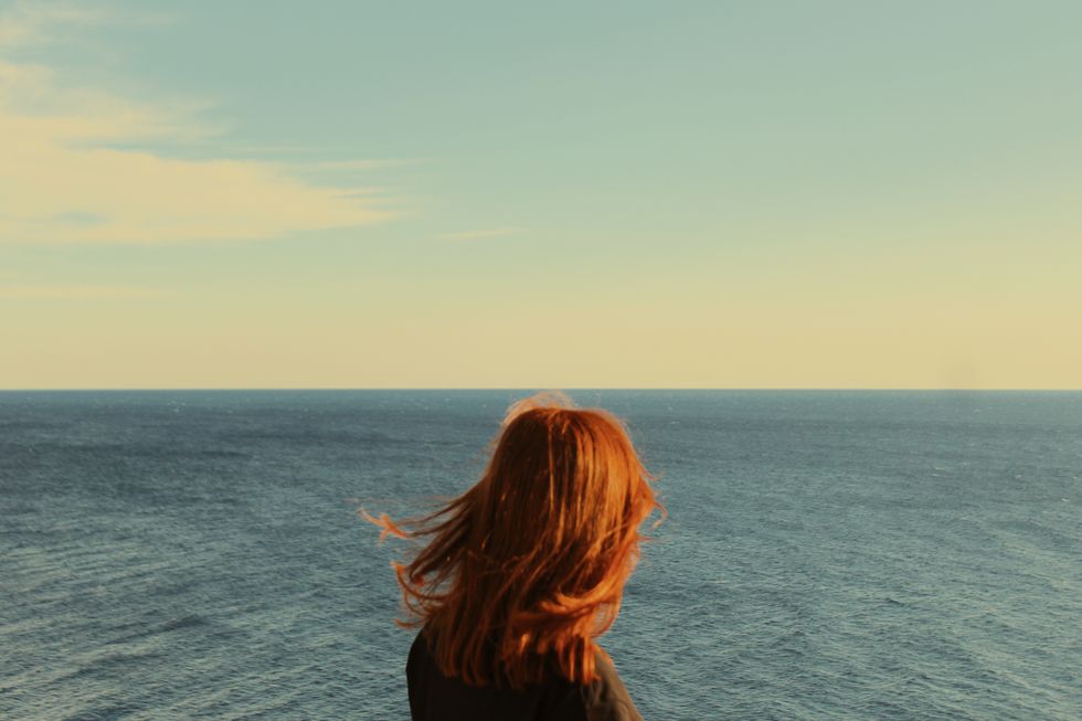 rear view of woman looking at sea against sky
