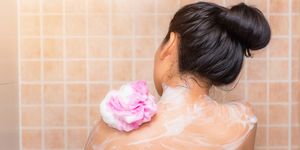 Rear View Of Woman Taking Bath At Bathroom
