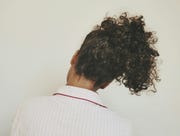 rear view of woman with curly hair against white background