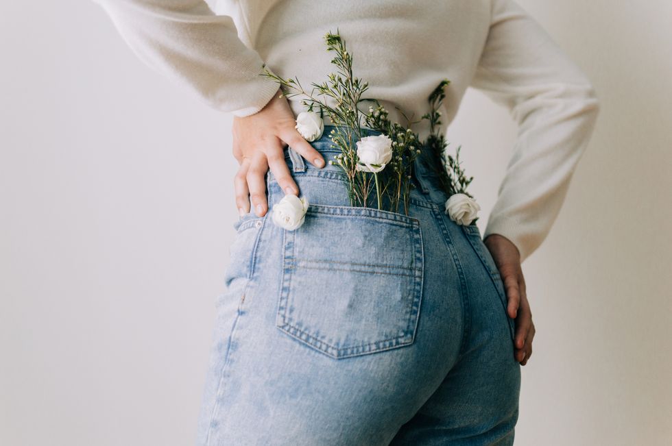 rear view of woman with flowers in pockets