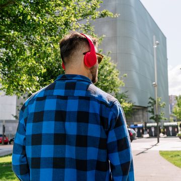 rear view of young man with red headphones outside