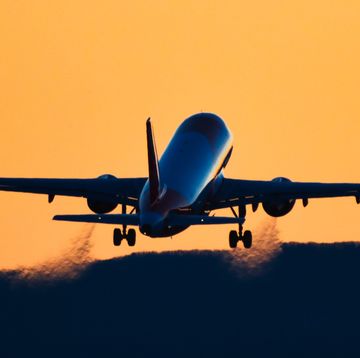 rear view silhouette of an airplane taking off at sunset