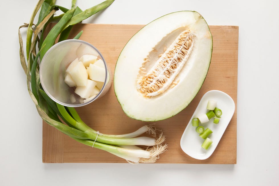 un melón partido a la mitad con cebolletas