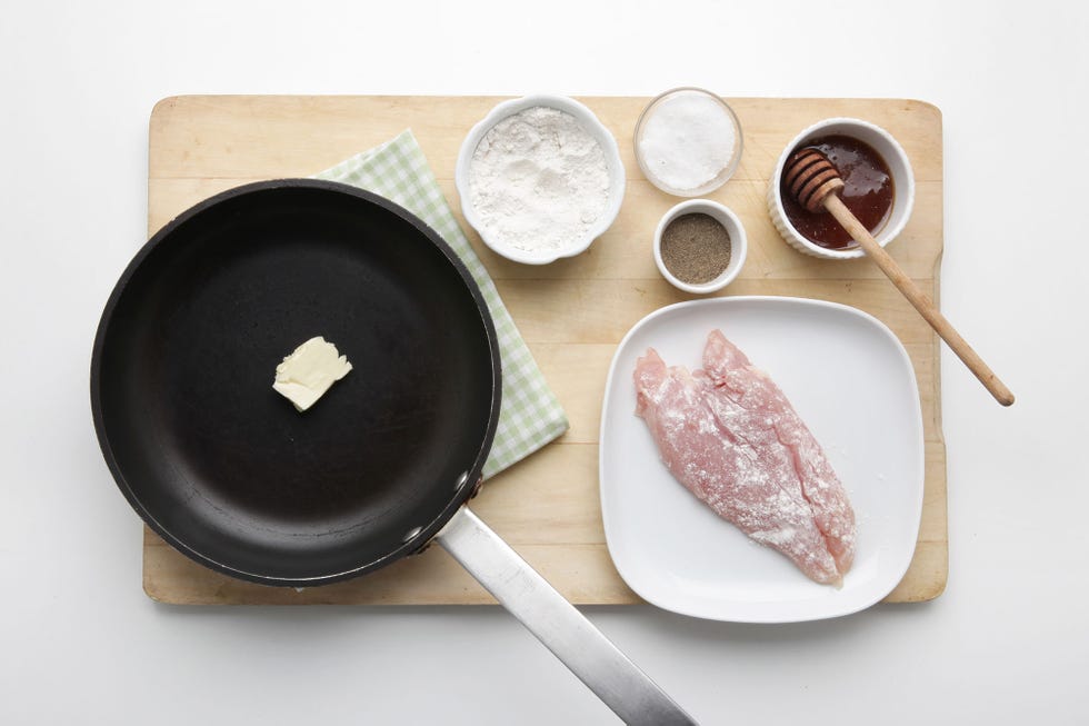 sarten con un trozo de mantequilla y un plato con una pechuga de pollo