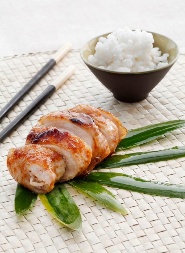 pollo teriyaki junto a unos palillos y un cuenco de arroz