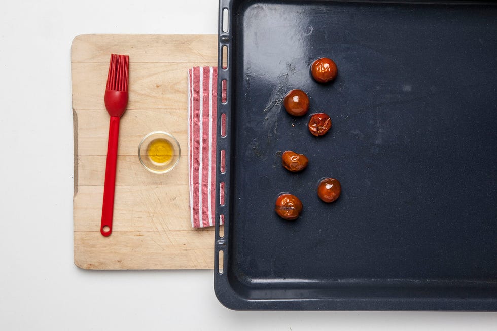 tomates mini embadurnados con aceite en una bandeja de horno