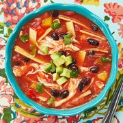 chicken tortilla soup overhead in blue bowl floral background