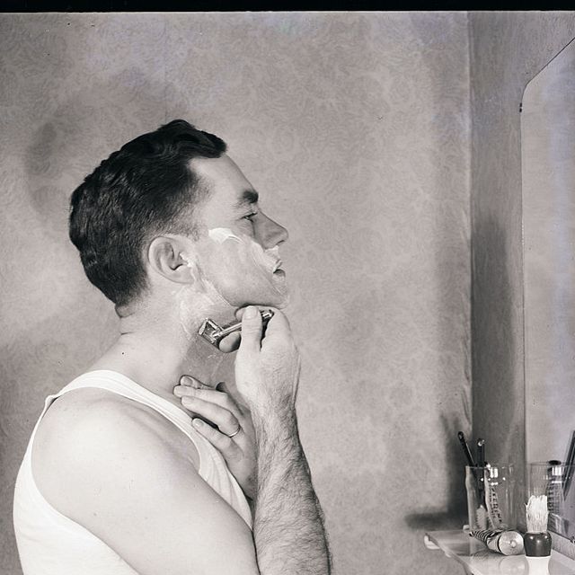 original caption herbert mears poses as he shaves his face in front of mirror undated photograph