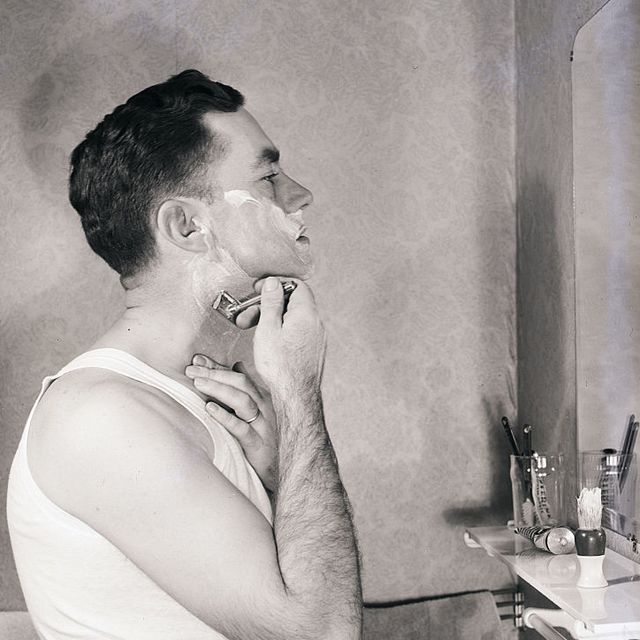 original caption herbert mears poses as he shaves his face in front of mirror undated photograph