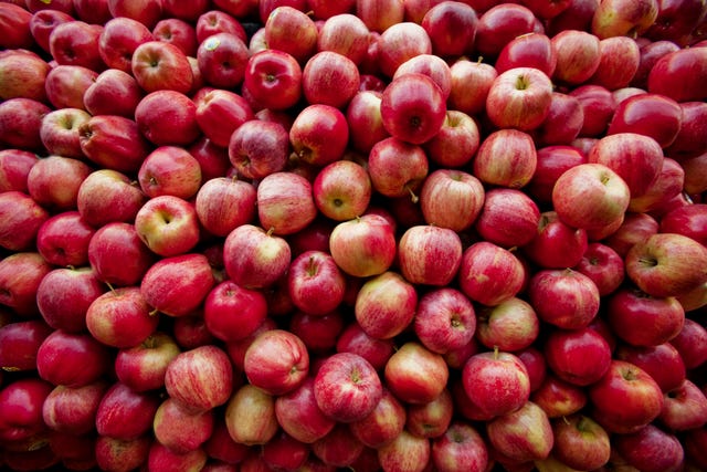 red apples lay in a pile at a fruit stand in maryland, usa