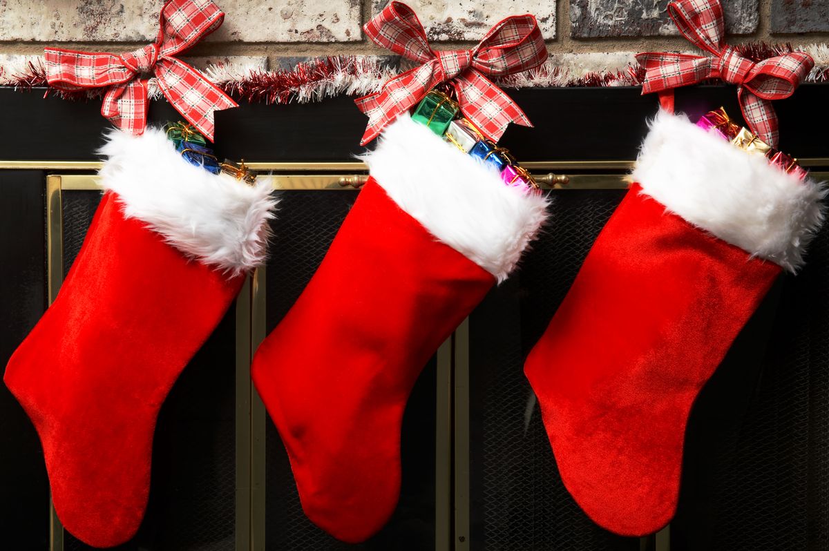 red christmas stockings hung up by tartan ribbon