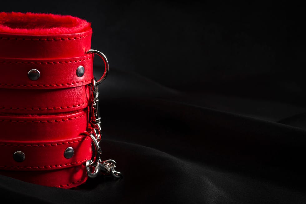 Red cuffs on black satin background with copyspace