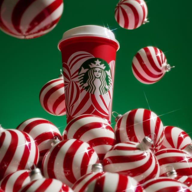 Festive coffee cup surrounded by red and white striped ornaments on a green background
