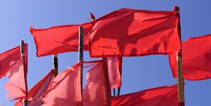 red fishing buoy flags on the boat moored in the dock against the blue sky