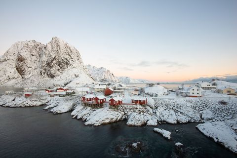 Red fishing house village among the snow with mountain view in Lofoten island Hamnoy Norway