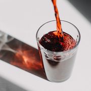 red fruit juice pouring in a drinking glass