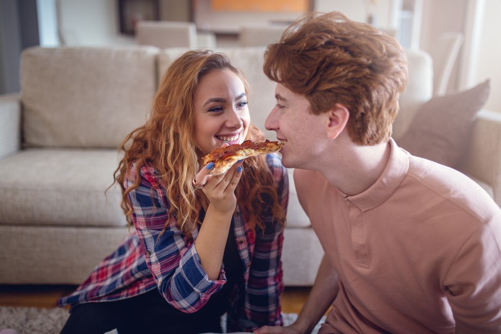 red haired teenager couple having pizza