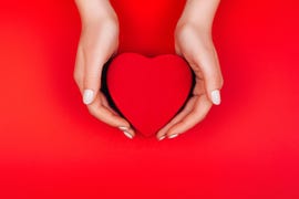 red heart gift box in woman hands