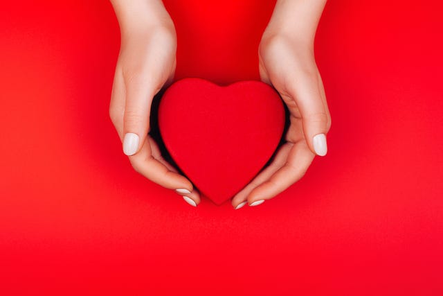 red heart gift box in woman hands