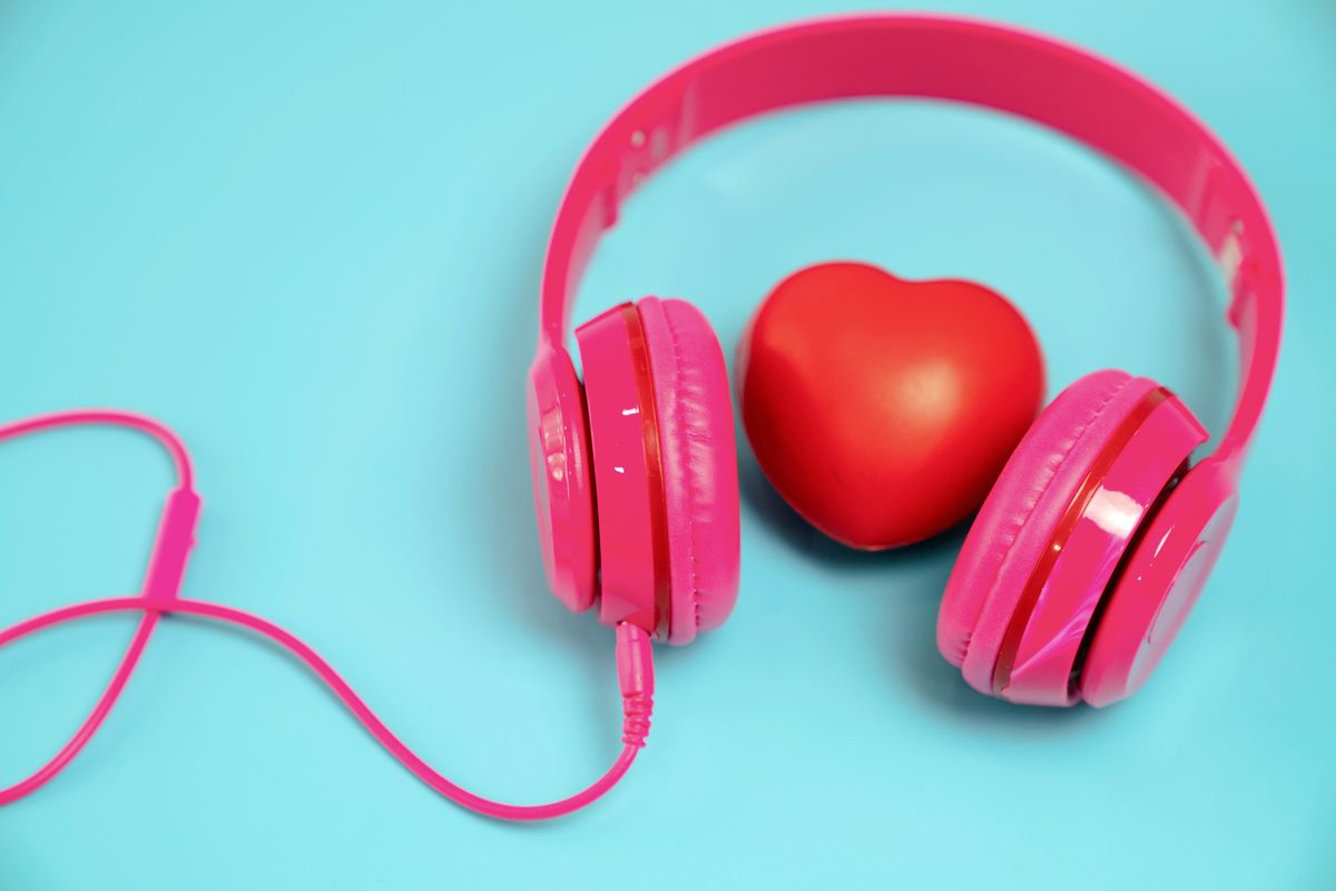 Red heart with headphones on blue background.