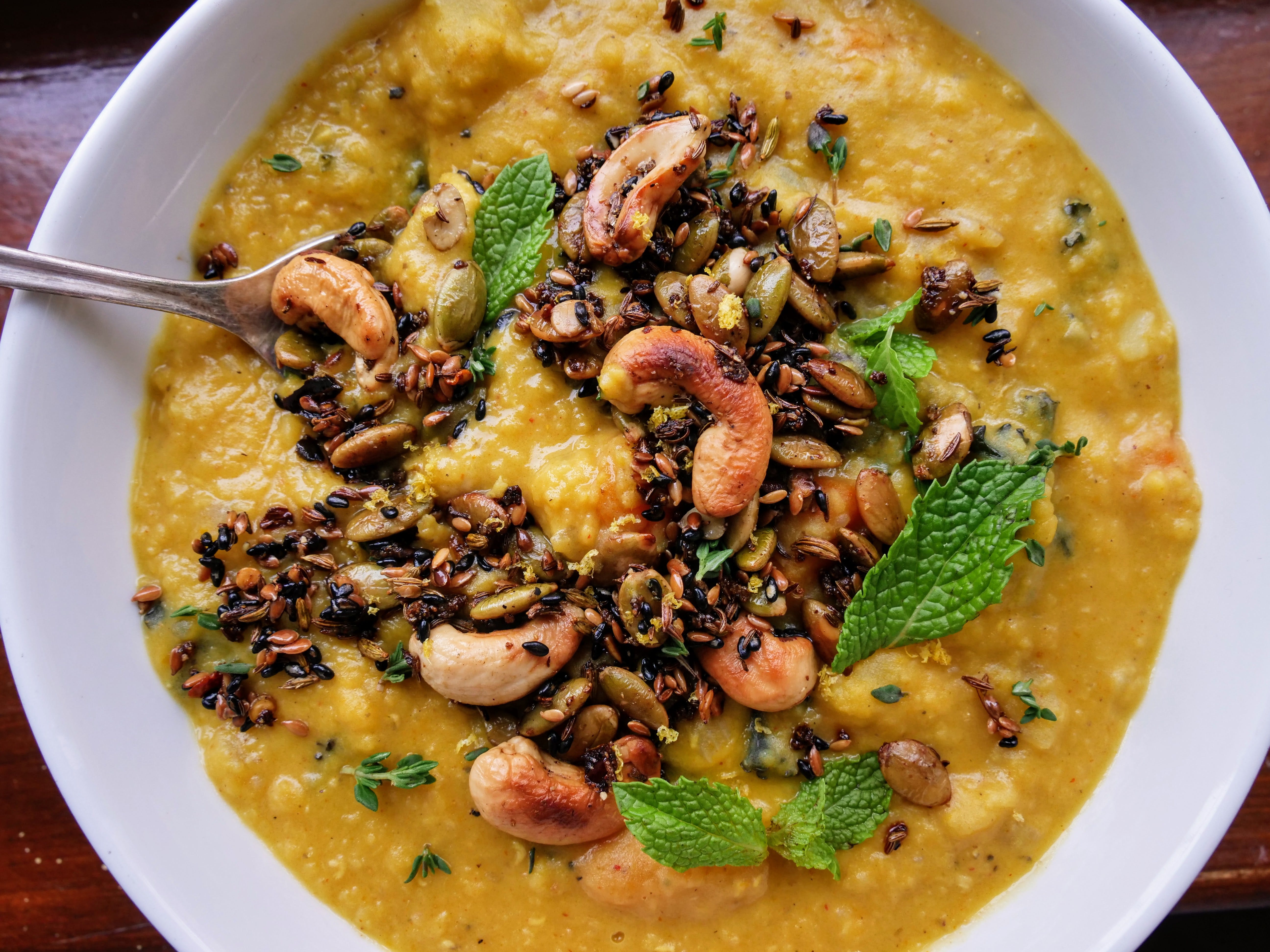 Fresh lentil soup in a white bowl, served in a restaurant setting