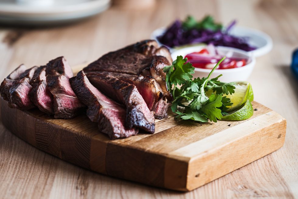 organic roasted steak sirloin fresh roast beef meat on wooden cutting board close up, salads