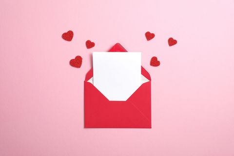 red paper envelope with blank white note mockup inside and valentines hearts on pink background flat lay, top view romantic love letter for valentine's day concept