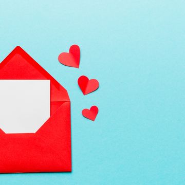 red paper envelope with empty white card and heart on blue background