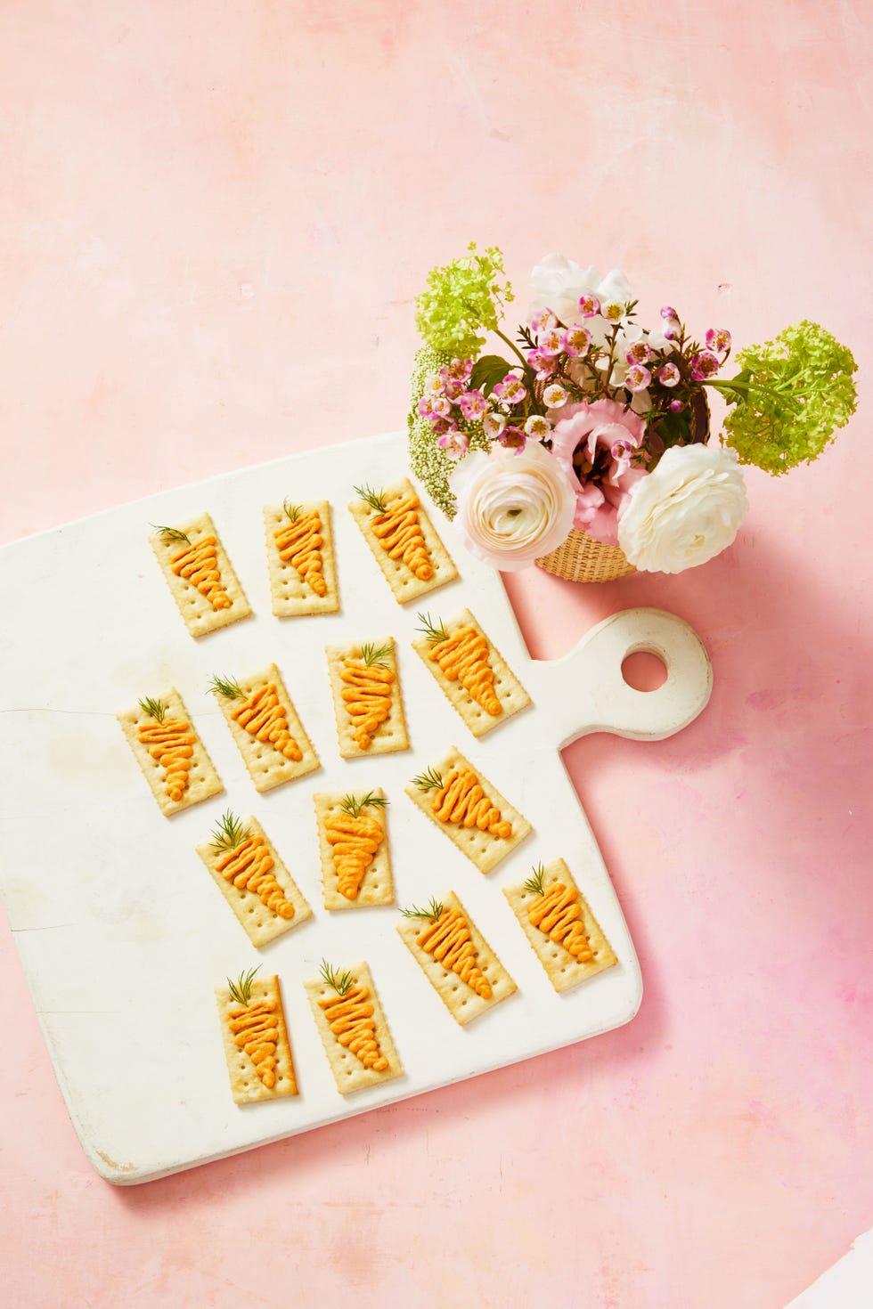 red pepper hummus crackers on a white cutting board