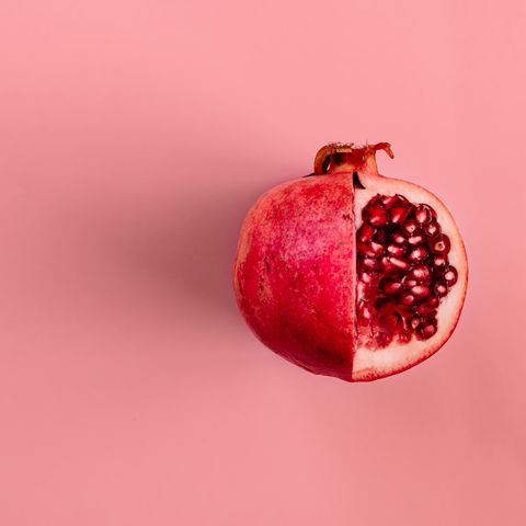 red pomegranate fruit on pastel pink background